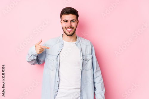 Young caucasian business man posing in a white background isolated person pointing by hand to a shirt copy space, proud and confident  mixto   © Asier