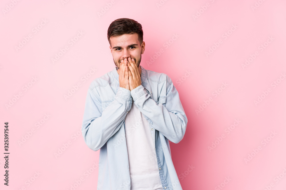 Young caucasian business man posing in a white background isolated laughing about something, covering mouth with hands.< mixto > Young caucasian business man posing in a white background isolated laughing about something, covering mouth with hands.< mixto >
