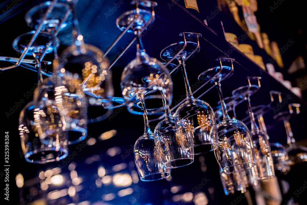 Wine and martini glasses in shelf above a bar rack in restaurant. Wine and martini glasses in shelf above a bar rack in restaurant.