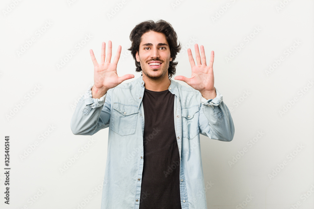 Young handsome man against a white background showing number ten with hands. Young handsome man against a white background showing number ten with hands.