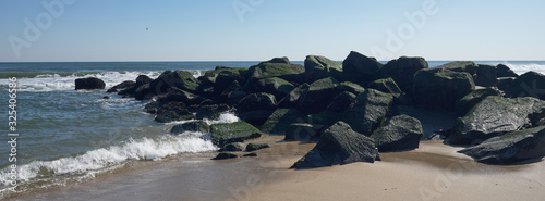 Photography Seaweed and moss covered rock jetty juts out into the Atlantic ocean off the sma