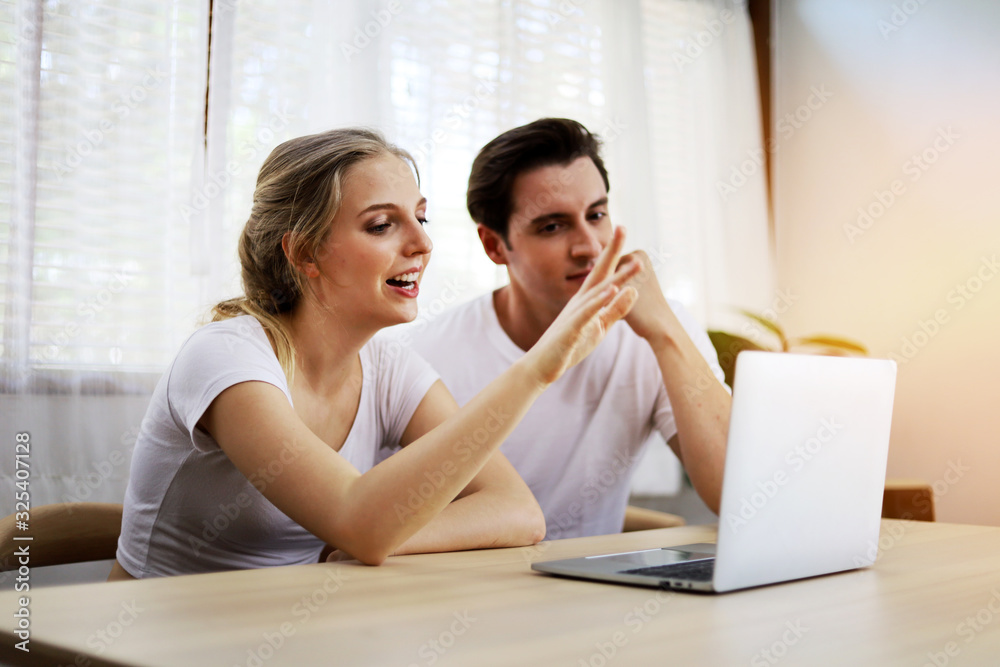 Happy couple lover talking and waving hand in a video conference on line with a laptop for contact frindship at home. Happy couple lover talking and waving hand in a video conference on line with a laptop for contact frindship at home.