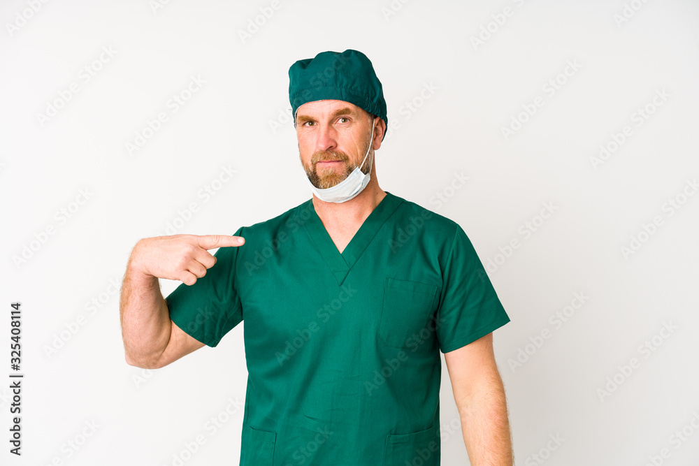 Surgeon senior man isolated on white background person pointing by hand to a shirt copy space, proud and confident Surgeon senior man isolated on white background person pointing by hand to a shirt copy space, proud and confident