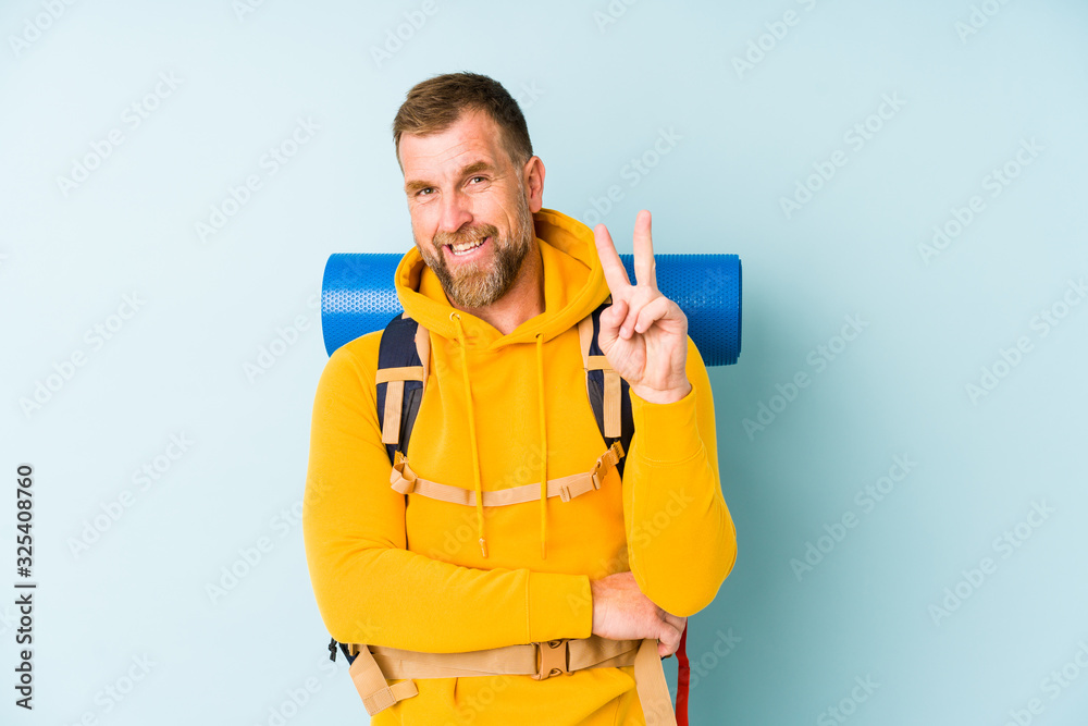 Senior hiker man isolated on blue background showing number two with fingers. Senior hiker man isolated on blue background showing number two with fingers.