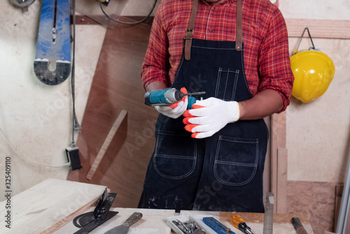 Hands with glove holding Electric cordless drill,prepare for working,wood work