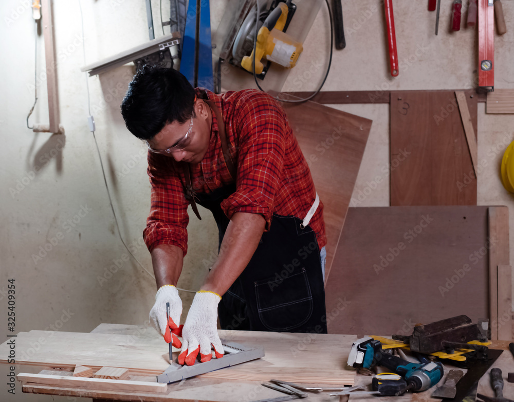 Handsome man doing wood work at factory,Handmade design,The carpenter Handsome man doing wood work at factory,Handmade design,The carpenter