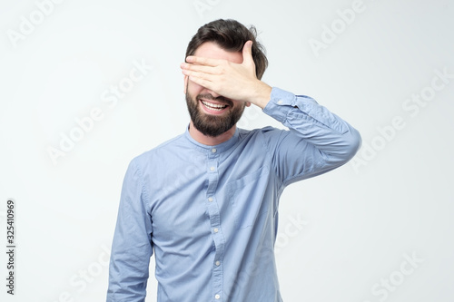 Young happy hispanic man screaming and covering eyes with hands © Viktor Koldunov