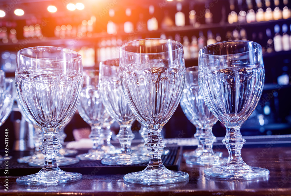 Wine and martini glasses in shelf above a bar rack in restaurant. Wine and martini glasses in shelf above a bar rack in restaurant.
