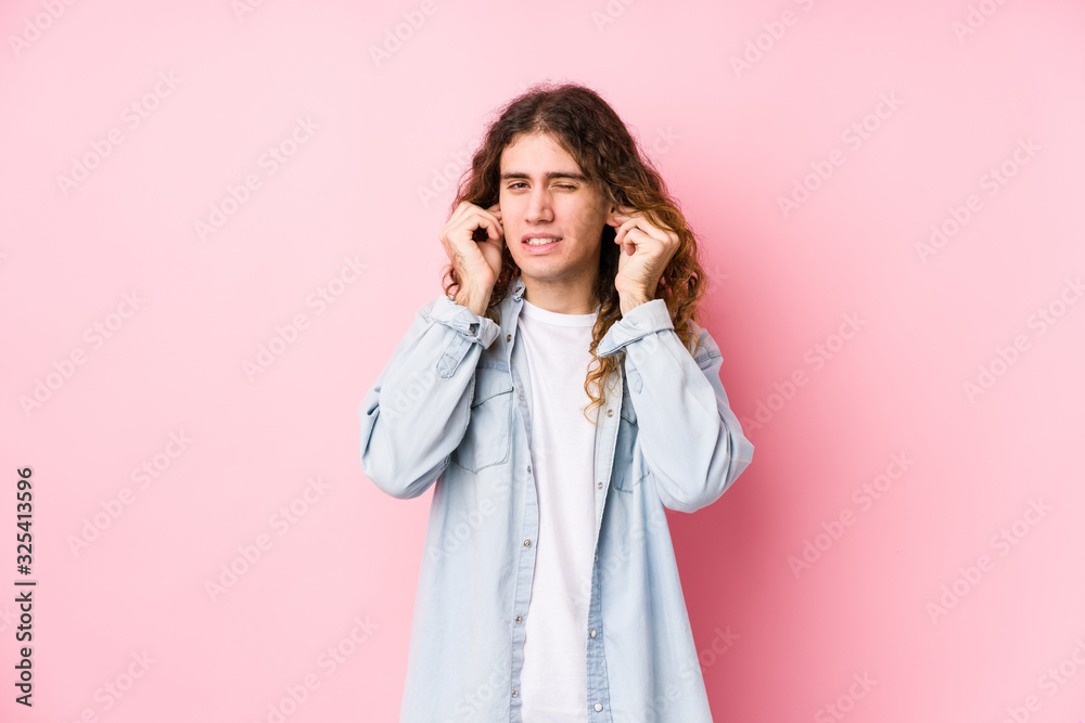 Long hair man posing isolated covering ears with hands. Long hair man posing isolated covering ears with hands.