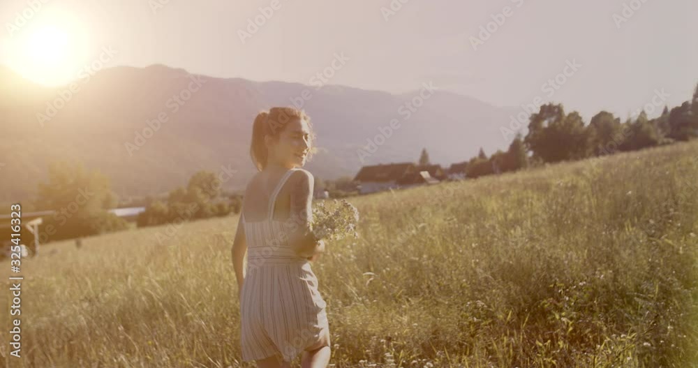 Girl runs across the field. In the hands of a bouquet of wildflowers. Low sunset. The concept of freedom, unity with nature. Shot on movie cameras with 12 bit colors. Girl runs across the field. In the hands of a bouquet of wildflowers. Low sunset. The concept of freedom, unity with nature. Shot on movie cameras with 12 bit colors.