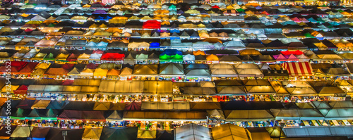 landscape view colorful of plastic roof of tent at ratchada train night market with dark sky of bangkok city. popular place for shopping at night.