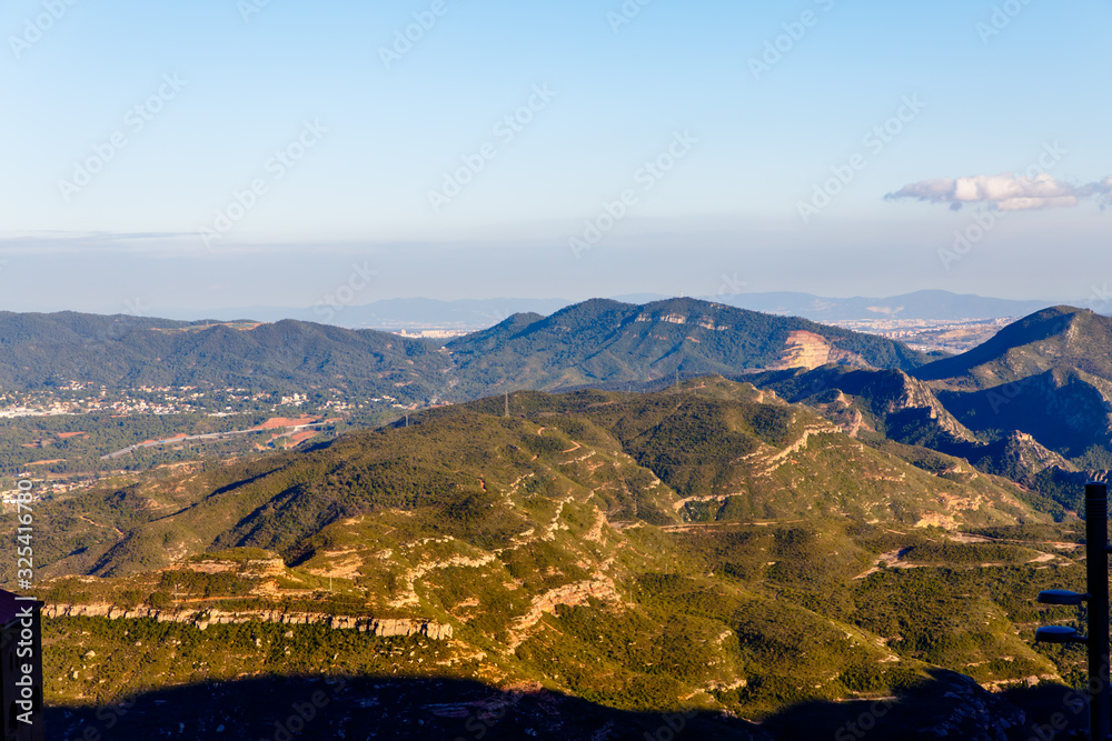 Evening in the mountains, the sun illuminates the peaks, and the lowlands are already in the shade. Spain