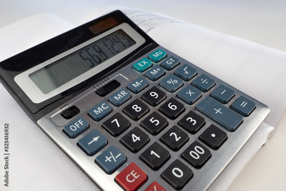 The calculator and documents are on the white table. Working with numbers. Accountant's workplace. Confirmation of expenses. Analysis of income and expenses. The calculator and documents are on the white table. Working with numbers. Accountant's workplace. Confirmation of expenses. Analysis of income and expenses.