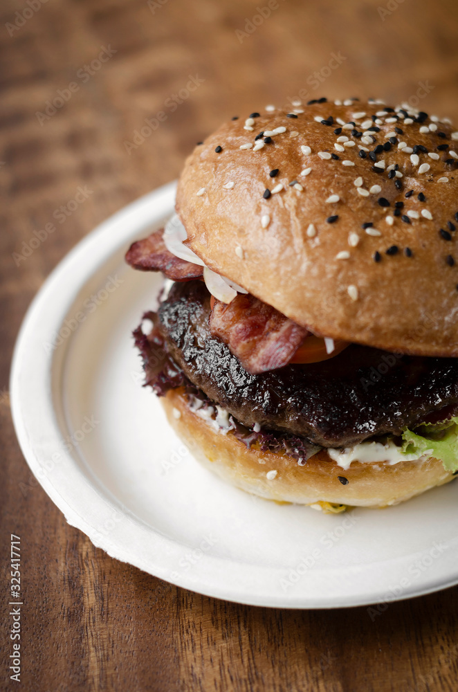 organic beef burger with bacon on wood table