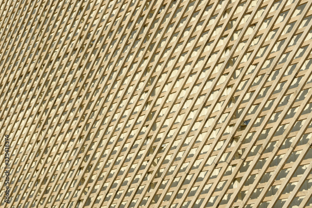 Wall of wooden planks. Lattice from a natural tree for weaving plants. Design for the decoration of buildings. Wood panel fence. Wall of wooden planks. Lattice from a natural tree for weaving plants. Design for the decoration of buildings. Wood panel fence.