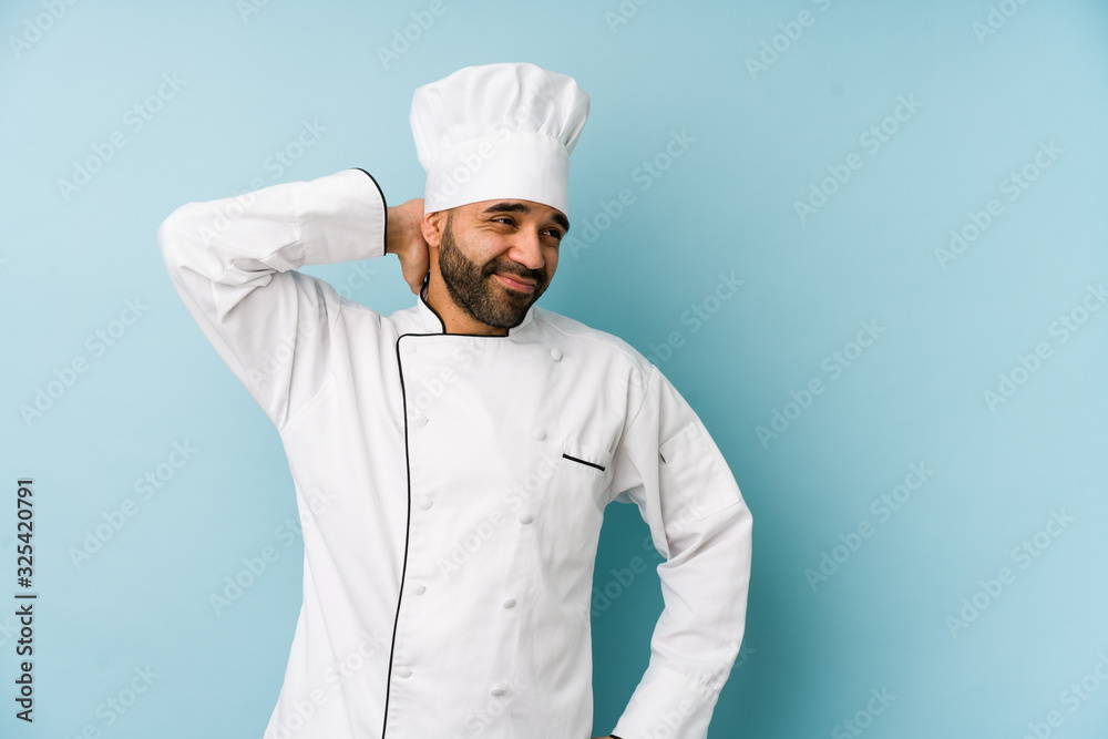 Young latin chef man isolated touching back of head, thinking and making a choice. Young latin chef man isolated touching back of head, thinking and making a choice.