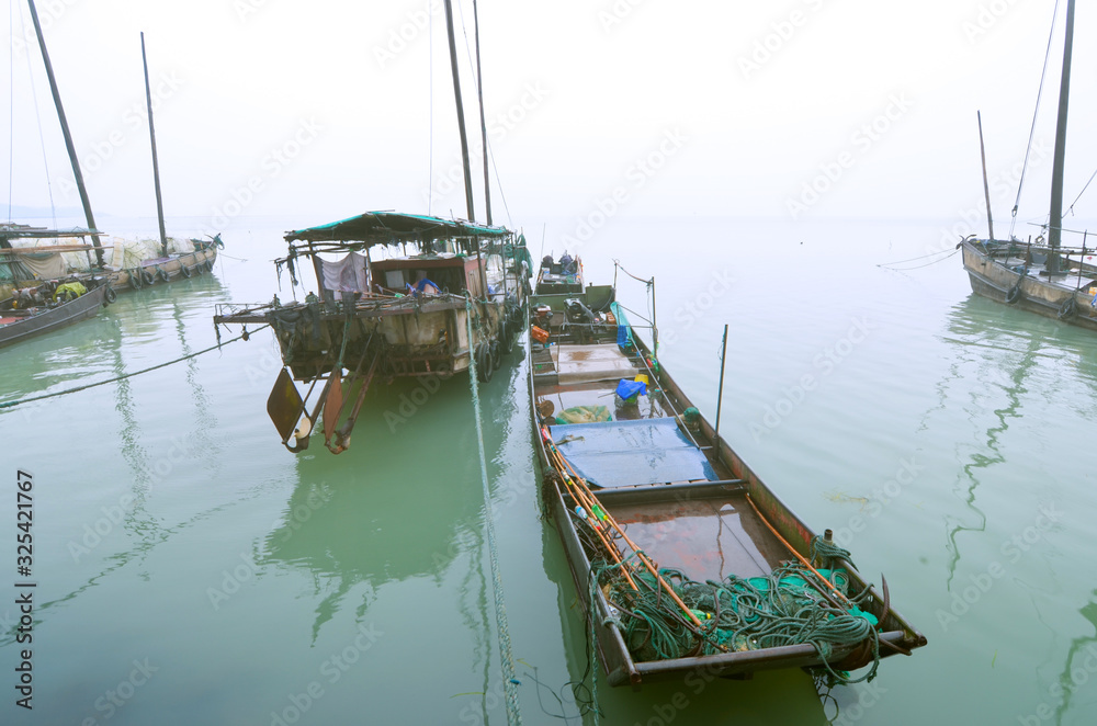 Fishing boats on the lake in the drizzle