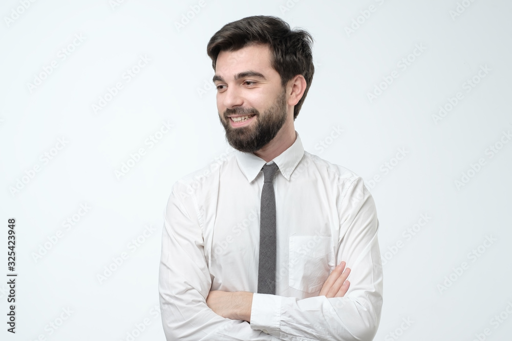 Hispanic young man standing with his arm crossed over white background Hispanic young man standing with his arm crossed over white background