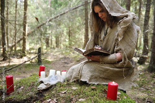Принти на полотні A man in a cassock spends a ritual in a dark forest