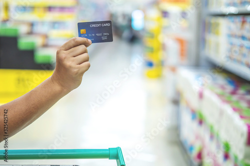 Close up of man hand holding credit card in supermarket, Finance concept. prepare for shopping online. copy space background for text