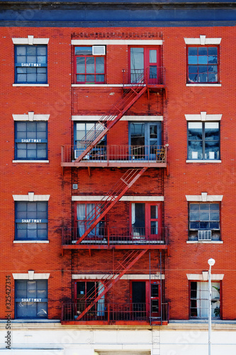Escape fire ladders at beautiful colorful house facades in New York. Manhattan New York City - Background texture pattern of Buildings.