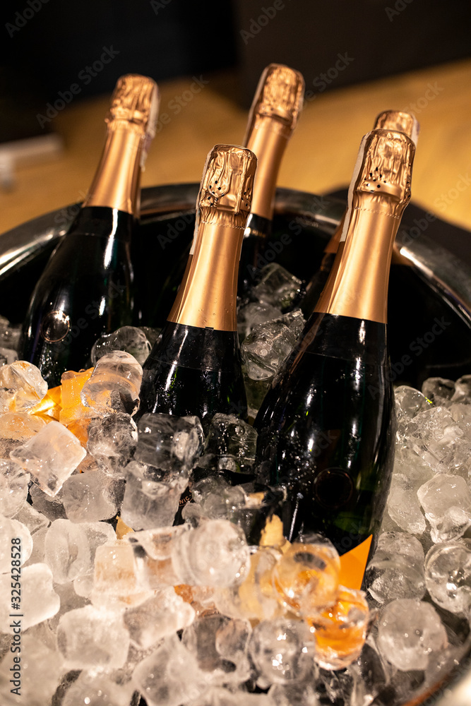 Bottles of champagne in cooler. Bottles in bucket of ice in the foreground. Selective focus