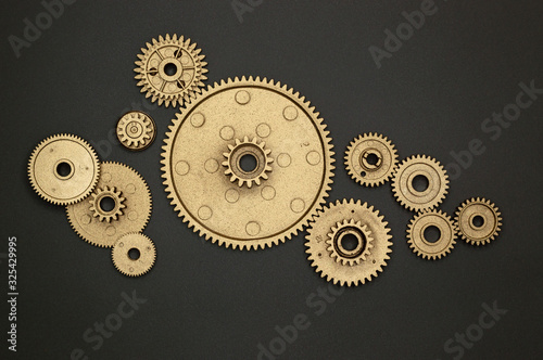 pile of golden gears on gray background