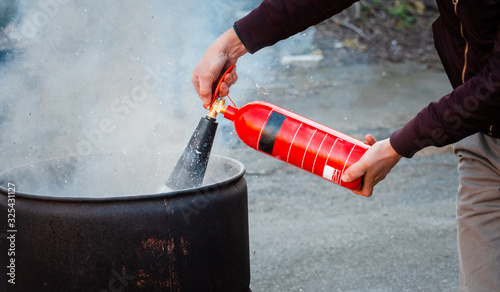 A man conducts exercises with a fire extinguisher. Fire extinguishing concept. Fire emergency incident