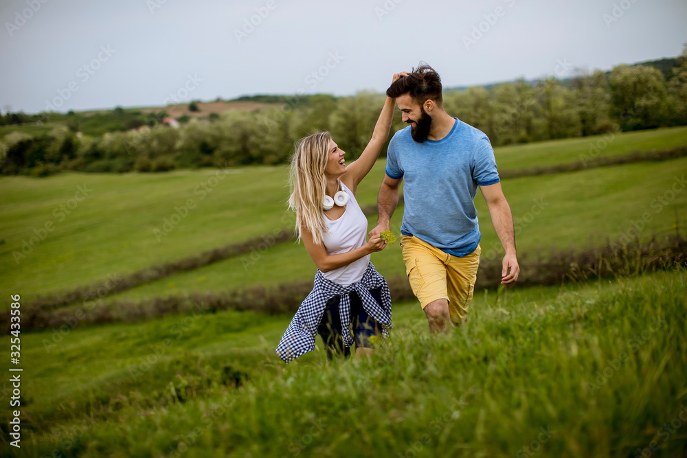 Loving couple enjoying a walk through grass land Loving couple enjoying a walk through grass land