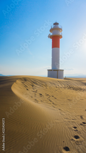 white and red lighthouse in a desert
