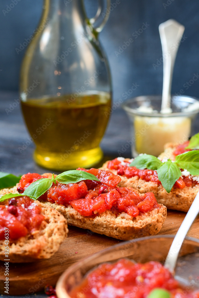 classic starter in an Italian restaurant: crostini (toasted bread) with tomatoes, olive oil, basil and parmesan. the bruschetta recipe. traditional lunch and dinner food  in Italy Rome Milan Florence