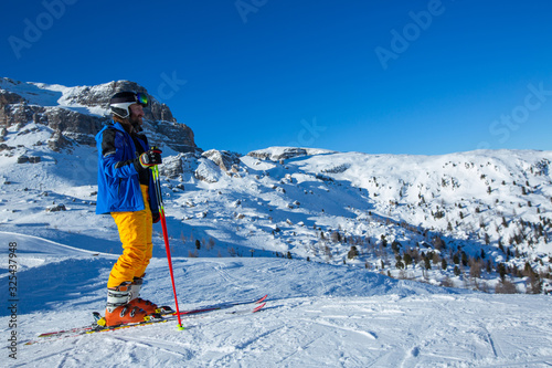 Skier stand on slope in winter mountains