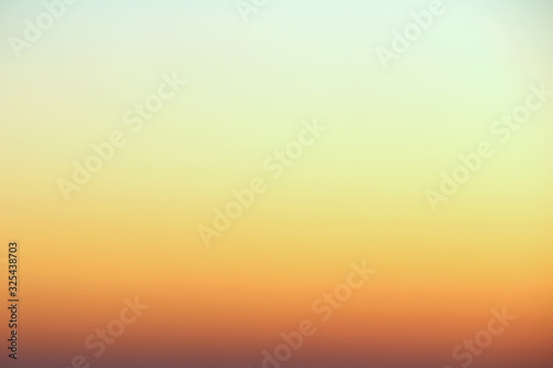 Flaming sky over the horizon during sunset or sunrise. Bright iridescent colors of yellow, orange and red. Colored background for text and design