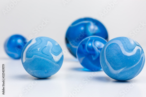 group of opaque and transparent glass marbles in blue with white swirls