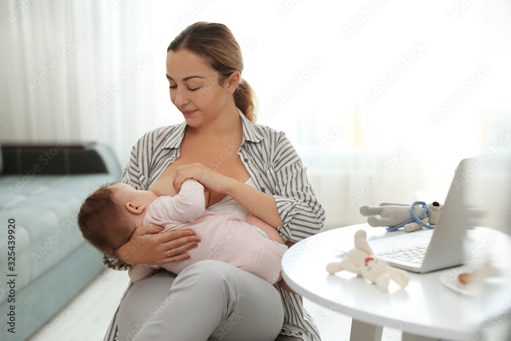 Young woman breastfeeding her baby at home Young woman breastfeeding her baby at home