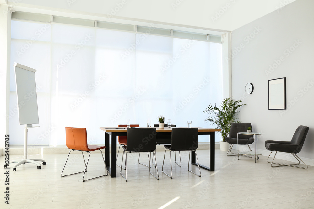 Fototapeta premium Simple office interior with large table and chairs