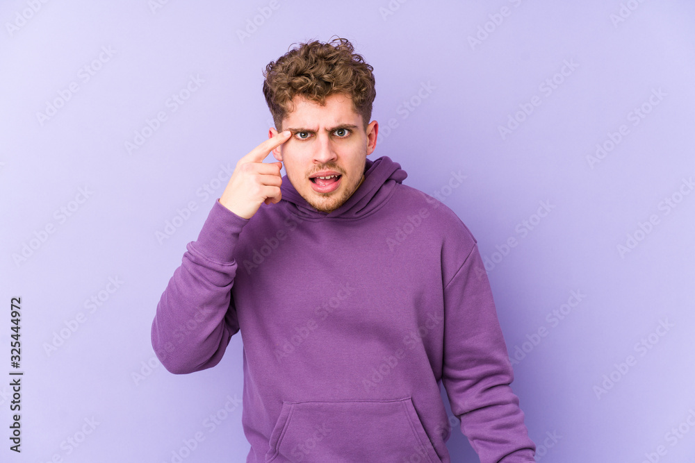 Young blond curly hair caucasian man isolated showing a disappointment gesture with forefinger. Young blond curly hair caucasian man isolated showing a disappointment gesture with forefinger.