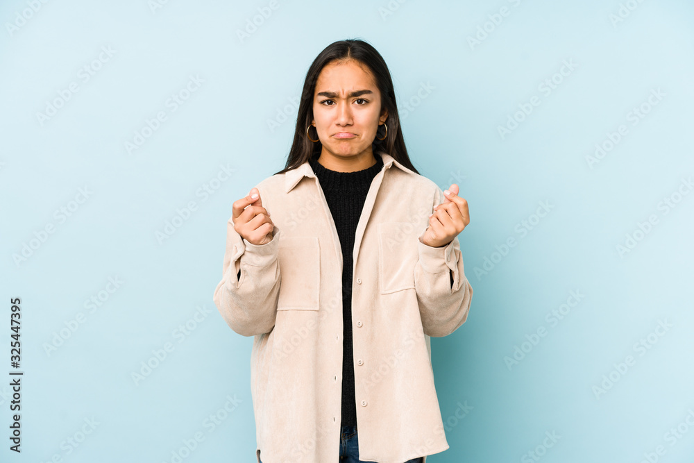 Young woman isolated on a blue background showing that she has no money. Young woman isolated on a blue background showing that she has no money.