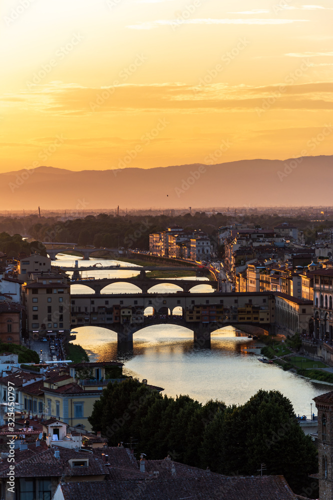 The famous bridge Ponte Vecchio in Florence over the river Arno during sunset
