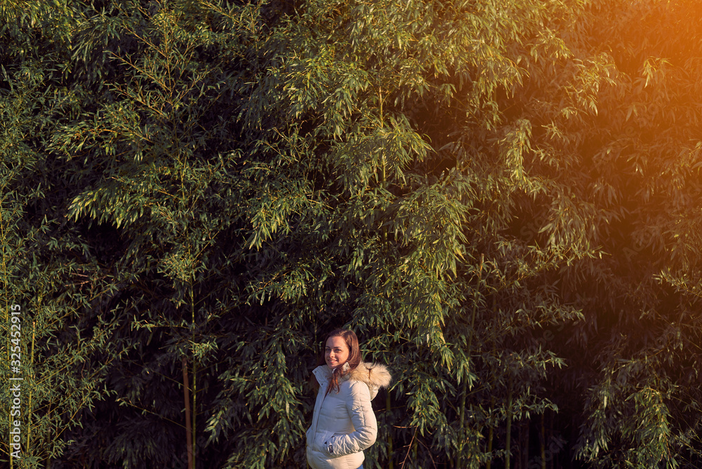 Young woman in front of a bamboo plantation Young woman in front of a bamboo plantation