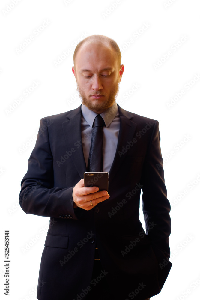Businessman in a black suit, shirt and tie using a mobile phone in order to keep abreast of all the news. Makes the photo on the mobile phone, writes notes or new contacts and plays the game. Businessman in a black suit, shirt and tie using a mobile phone in order to keep abreast of all the news. Makes the photo on the mobile phone, writes notes or new contacts and plays the game.