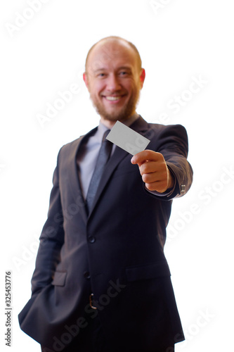 Successful businessman in black suit, shirt and tie shows his new business card. The template for the presentation of business cards or company logo. Man gives his business card at a meeting.