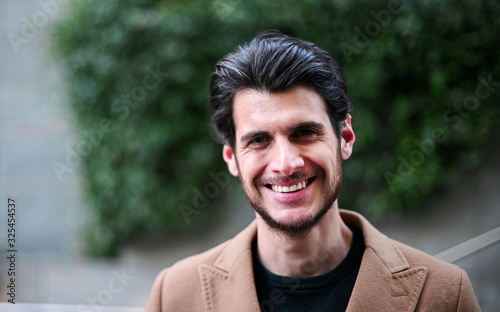 Handsome young man smiling outdoor in casual elegant cloths