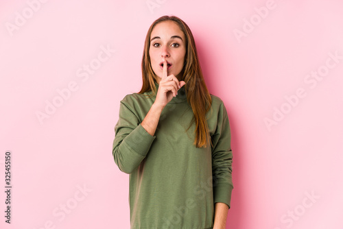 Young caucasian woman posing isolated keeping a secret or asking for silence.