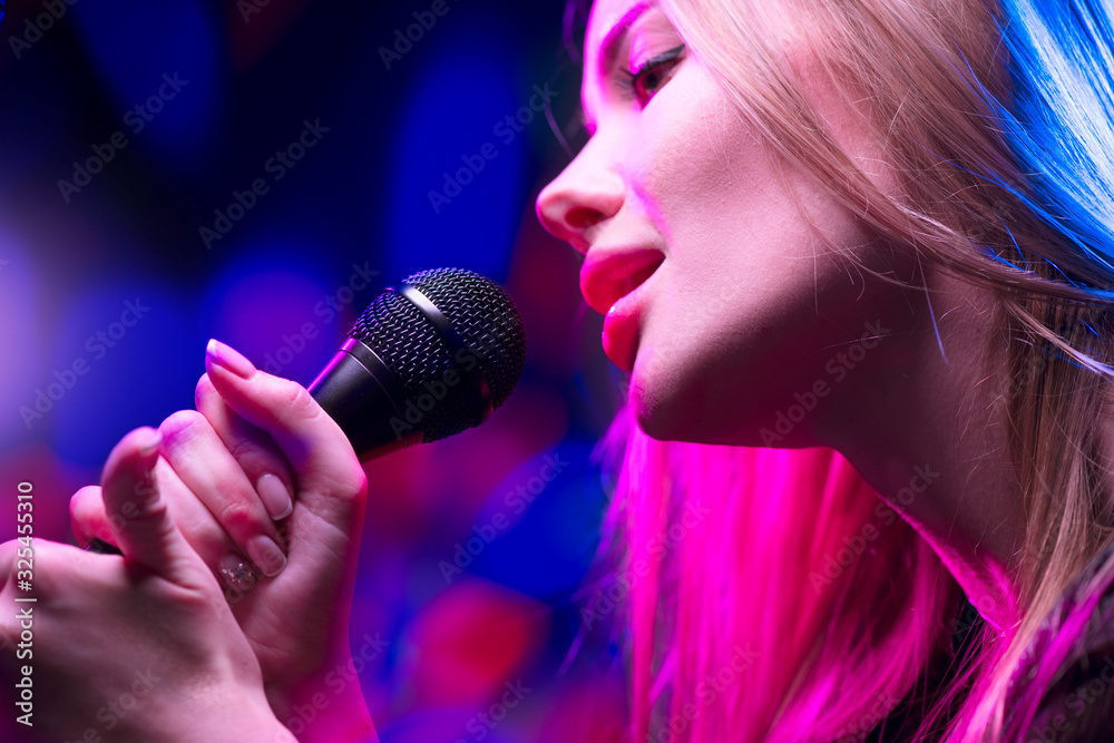 Beautiful Singing Girl, Beauty Glamour fashion Woman with Microphone over Blinking bokeh night background. Glamour Model Singer. Karaoke song, party. Rock star singer on music concert. Beautiful Singing Girl, Beauty Glamour fashion Woman with Microphone over Blinking bokeh night background. Glamour Model Singer. Karaoke song, party. Rock star singer on music concert.