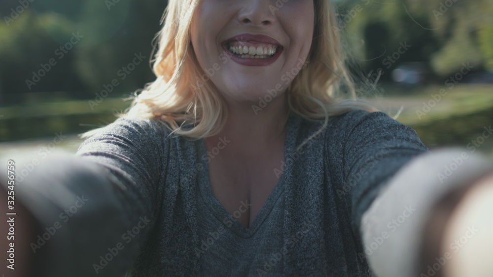 Pretty Blonde Girl Take Selfie Rotation Closeup. Delightful Woman Plus Size Hold Digital Device Rotate Motion. Caucasian Lady Enjoy Happy Moments Urban Park Background Happiness Concept