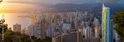 Breathtaking aerial panoramic view of summer resort with beach and famous skyscrapers. Beautiful sunset over city. Costa Blanca. City of Benidorm, Alicante, Valencia, Spain.