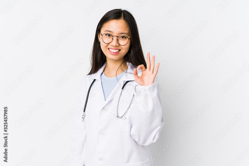 Young doctor chinese woman isolated cheerful and confident showing ok gesture. Young doctor chinese woman isolated cheerful and confident showing ok gesture.