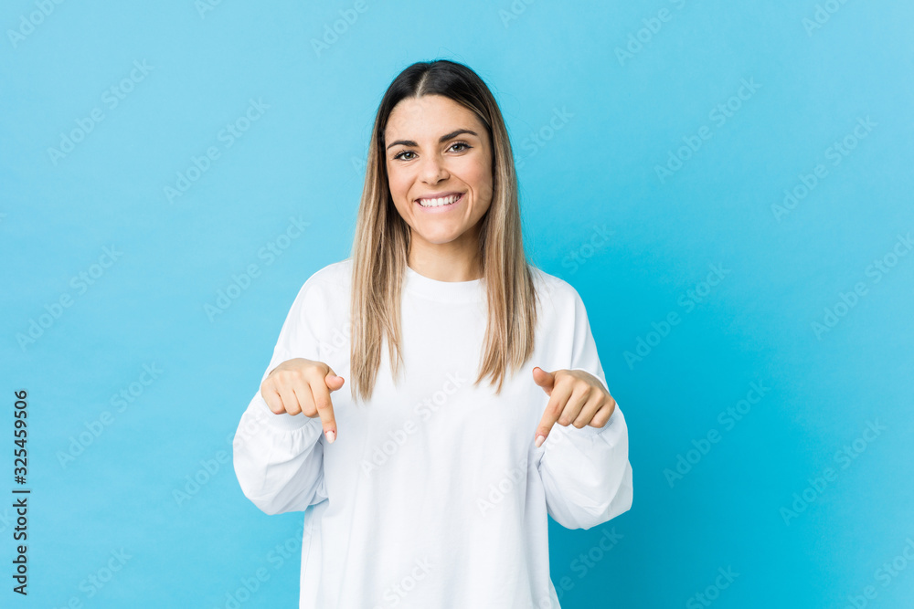 Fototapeta premium Young caucasian woman isolated points down with fingers, positive feeling.