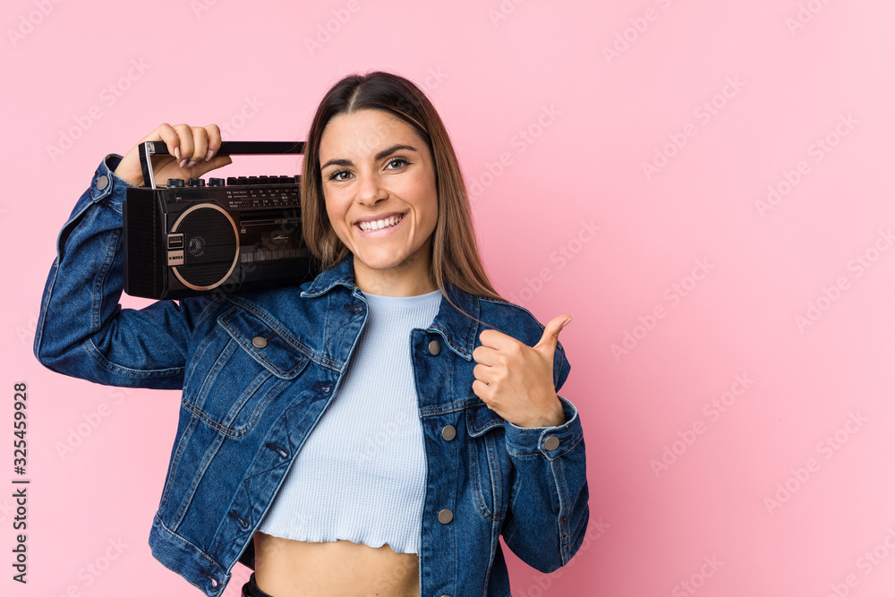 Young caucasian woman holding a guetto blaster smiling and raising thumb up Young caucasian woman holding a guetto blaster smiling and raising thumb up